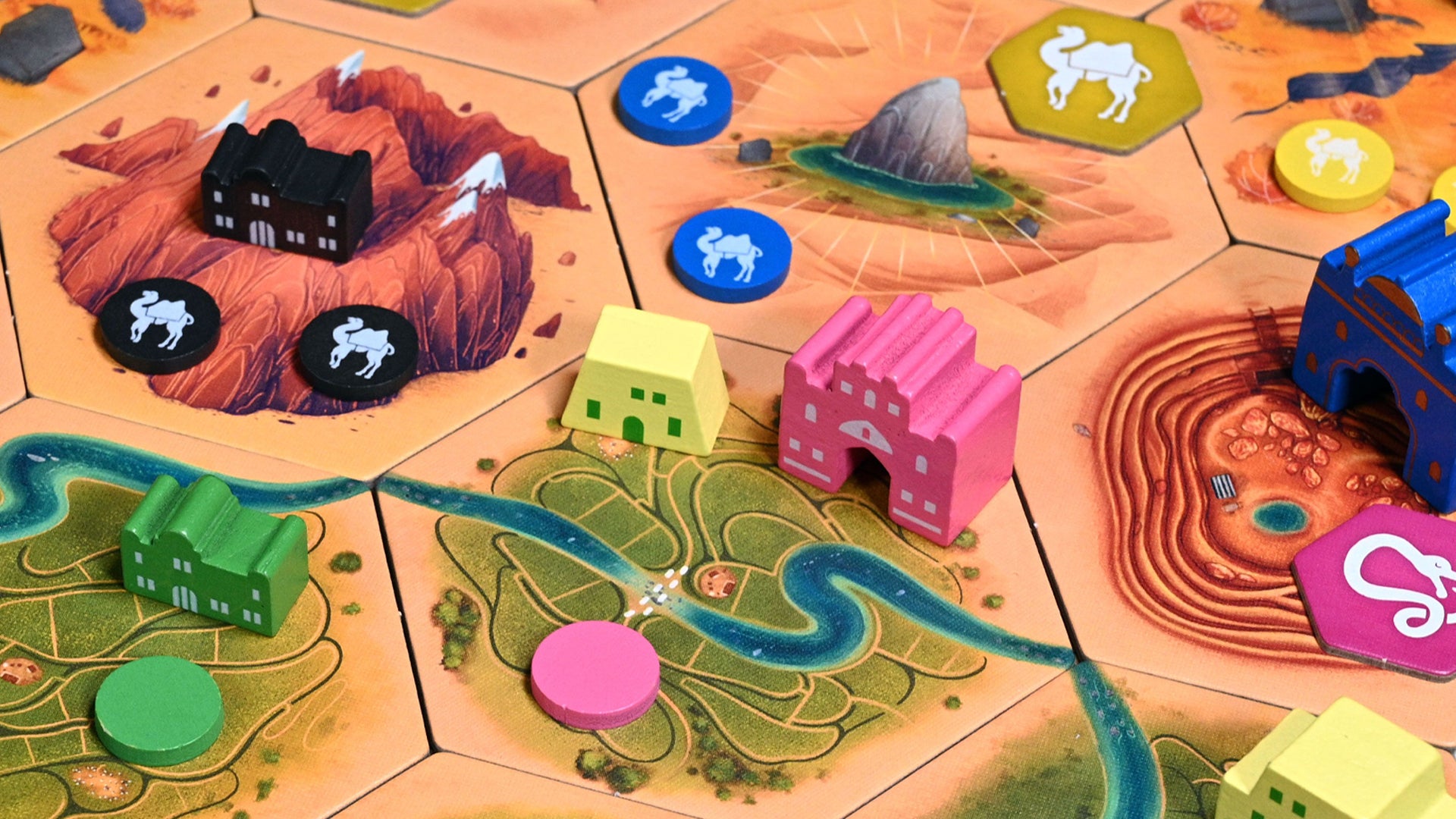 A close-up image of Crescent Moon gameplay, showing wooden tokens and pieces on cardboard hex tiles