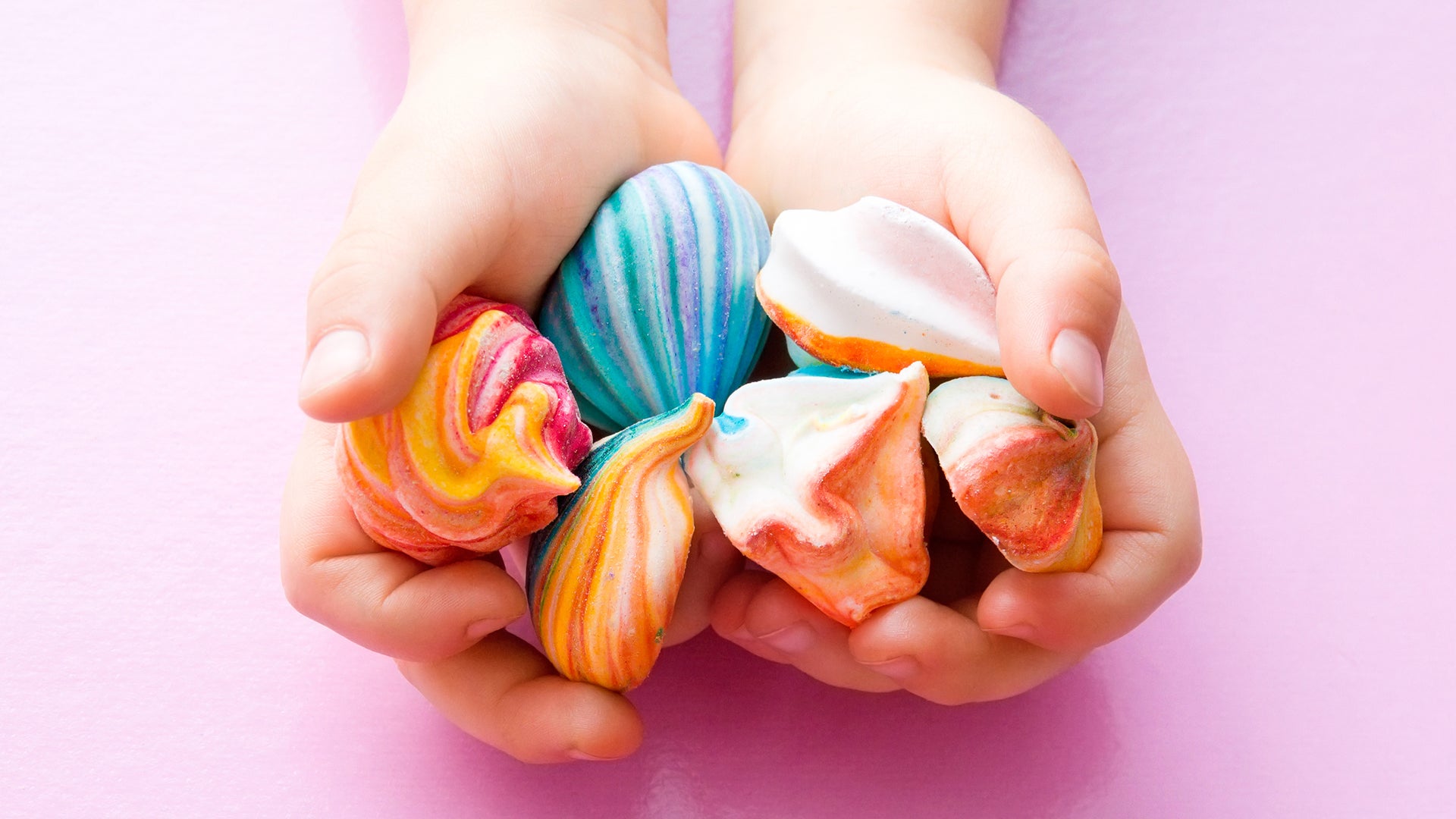 Colourful meringues in hands