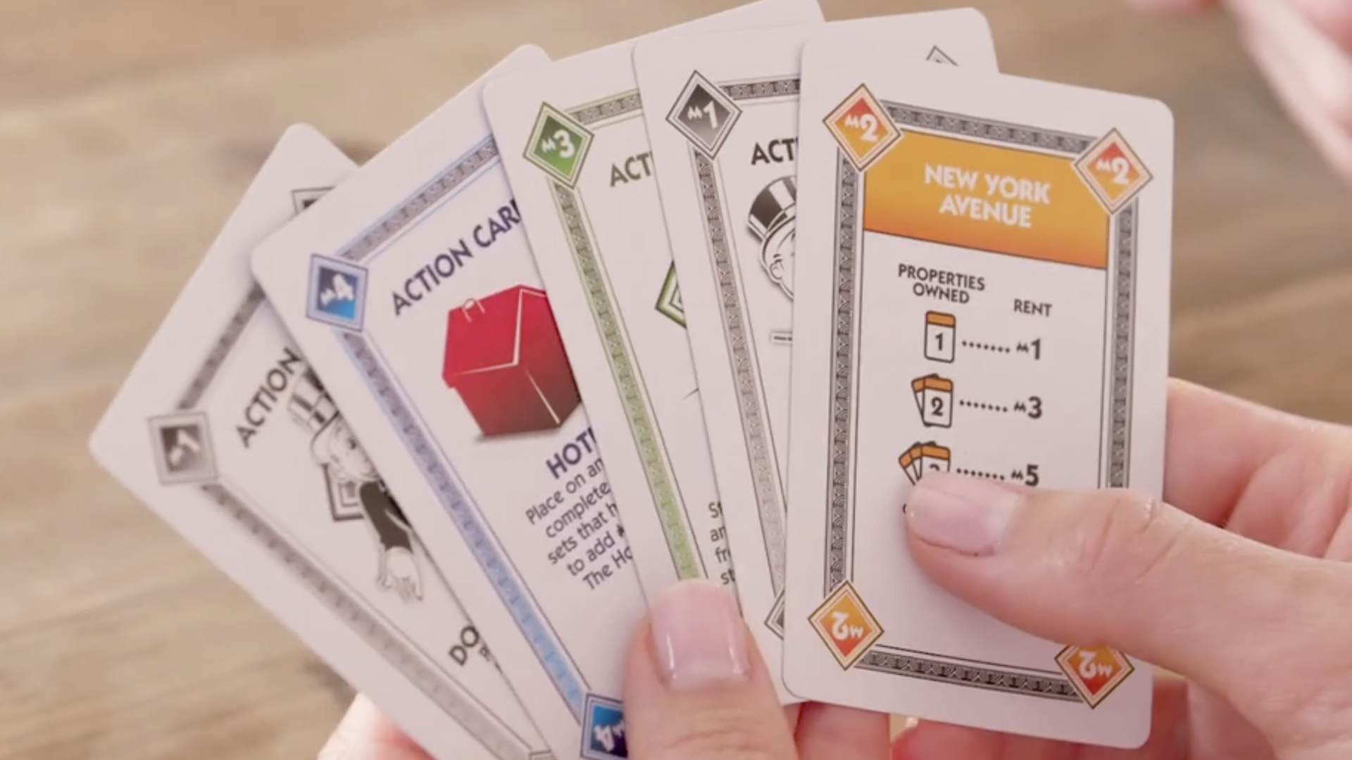 Monopoly Deal cards held in hands